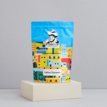 A 1 kilo bag of Latino Blend sits atop an ivory coloured platform.