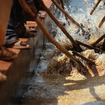 Workers use hand-made racks, made of wood, to rack the coffee through concrete channels of water to clean off the mucilage from the bean.