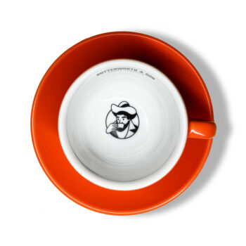 Coffee Man Cup and saucer, in orange. Top down view showing Coffee Man logo in base of cup.