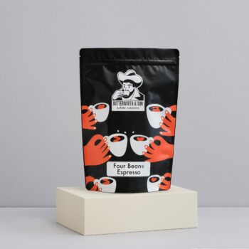 A 1 kilo bag of 4 bean sits atop an ivory coloured platform.