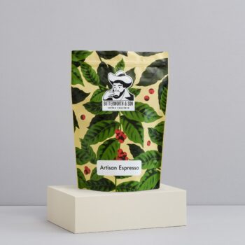 A 1 kilo bag of Artisan Espresso sits atop an ivory coloured platform.